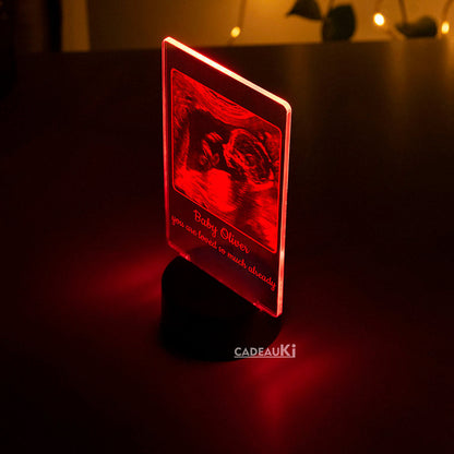 Rote LED-Lampe mit eingravierter Ultraschallfoto eines Babys.
Ein einzigartiges personalisiertes Geschenk für werdende Mütter.