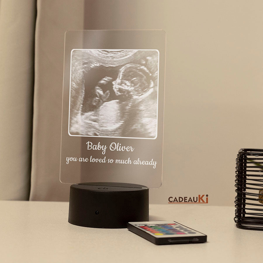 Lila leuchtende LED-Lampe mit detaillierter Gravur einer Ultraschallaufnahme.
Stilvolle Erinnerung für werdende Eltern.